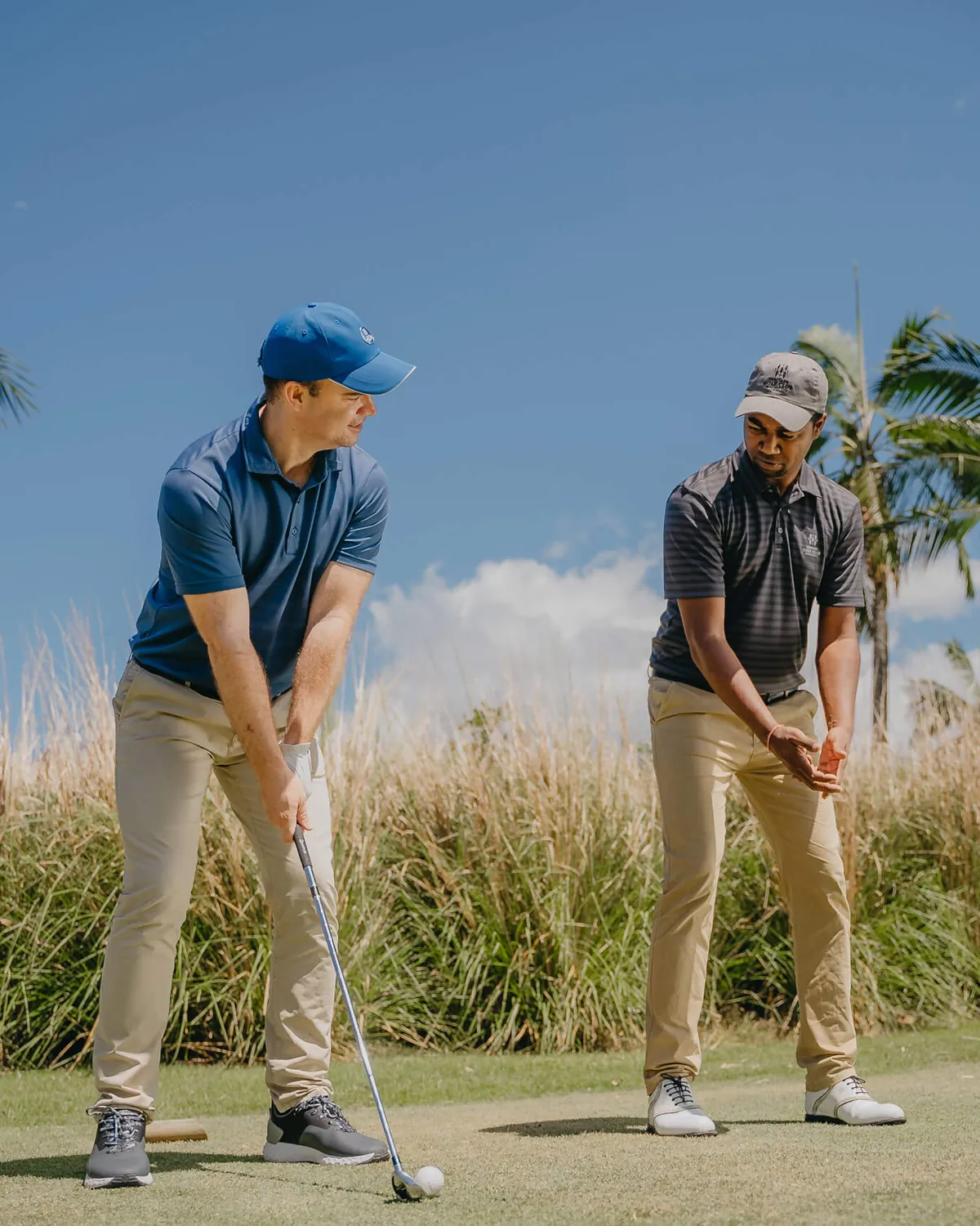 Golf Pro gibt einem Schüler Unterricht auf der Driving Range auf Mauritius